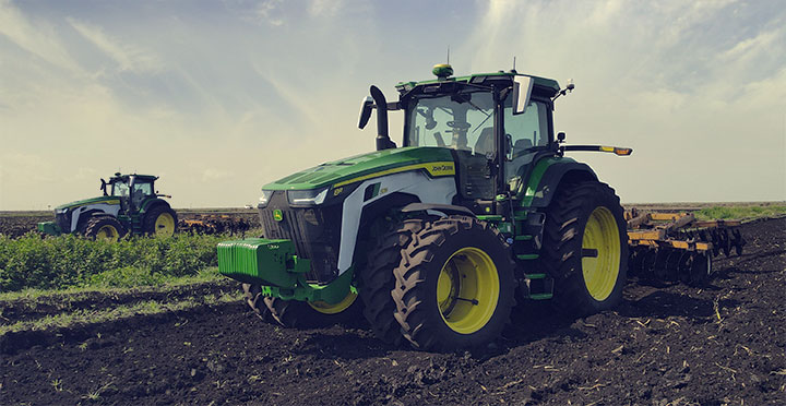 image of multiple tractors tilling a field
